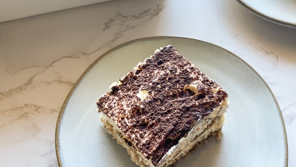 Slice of tiramisu cake on white plate