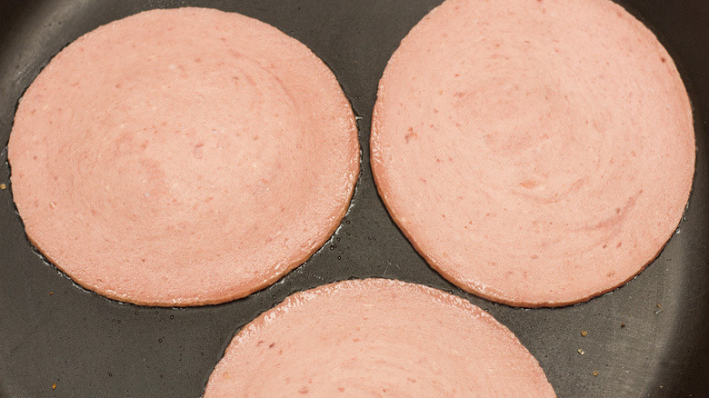 Cooked bologna slices in pan