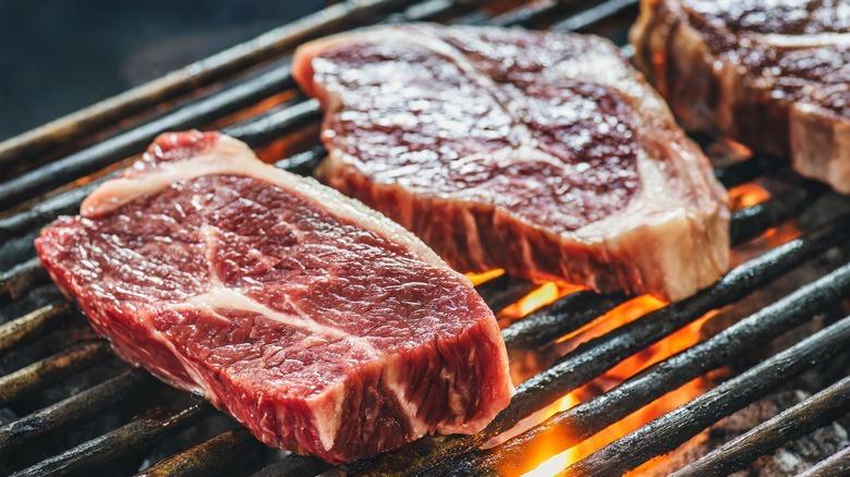 grass-fed ribeye steak cooking over fire