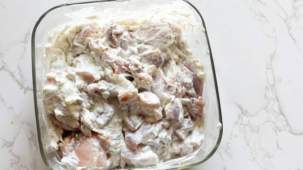 Pieces of chicken in a tzatziki sauce for Greek chicken souvlaki