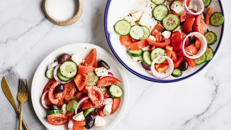 one large bowl and small serving of Greek salad