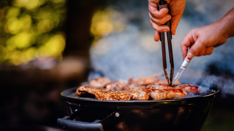 picking grilled meat with tongs