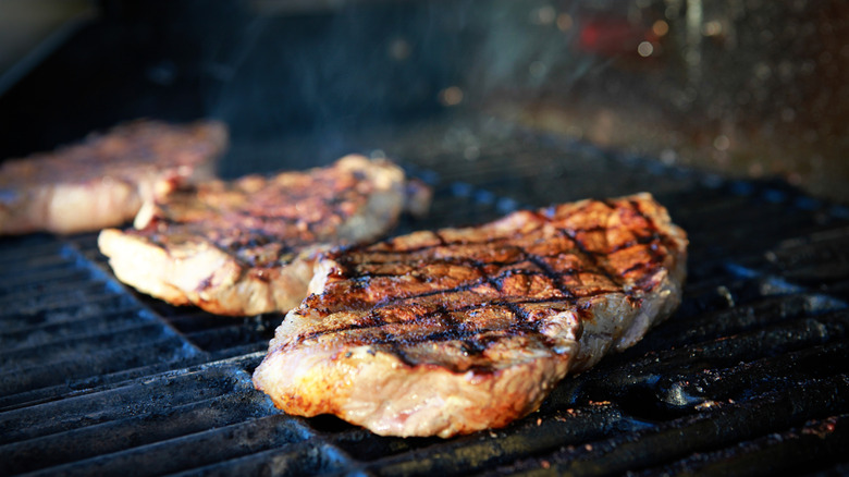 ribeye steaks on charcoal grill