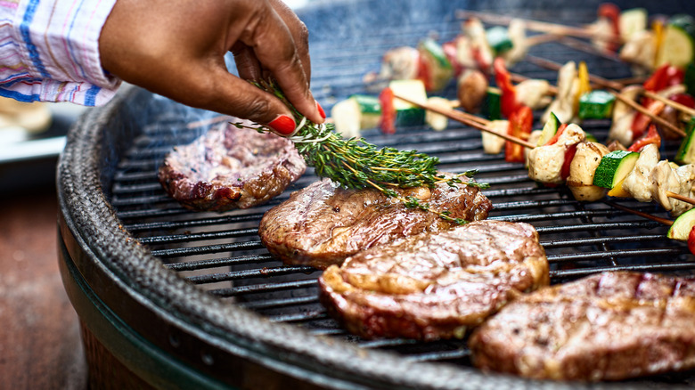 steaks on grill with kebabs