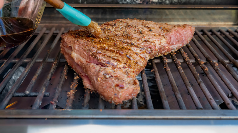 glazing a tri-tip on the grill 