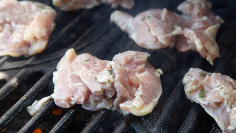 raw chicken thighs on grill