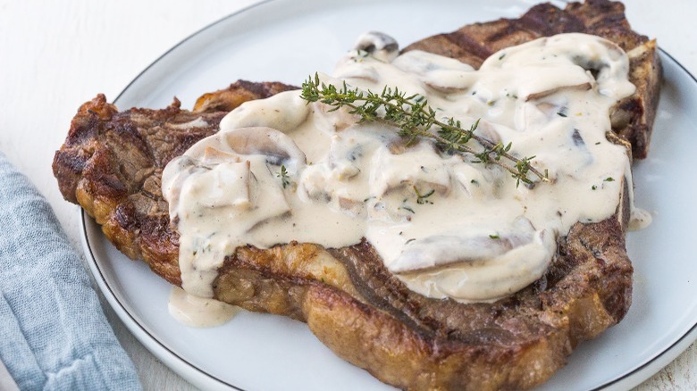 porterhouse on plate with cream and thyme