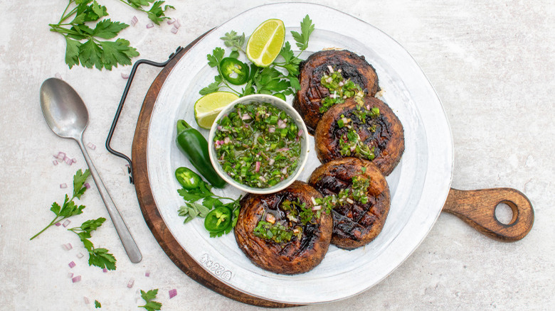 grilled portobello mushrooms with jalapeño chimichurri on chopping board