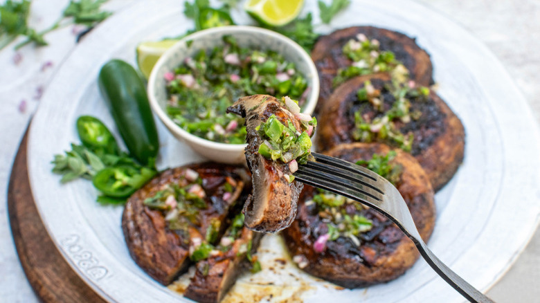 chimichurri on grilled mushrooms with fork