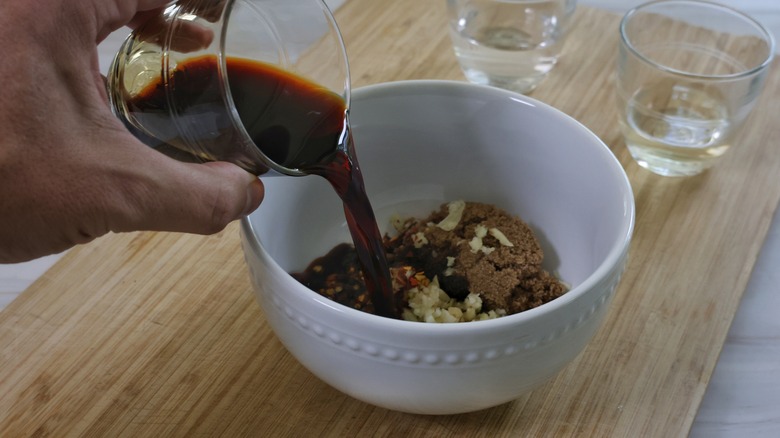 pouring soy sauce into bowl