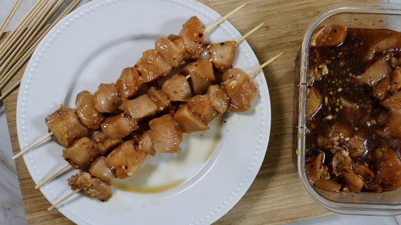 raw chicken skewers on plate