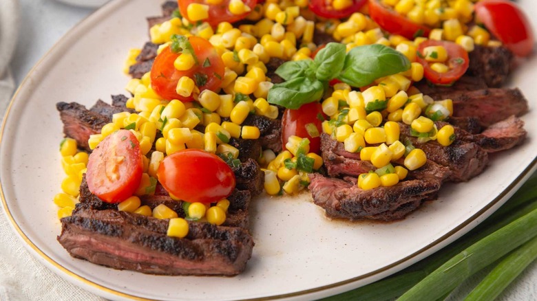 skirt steak topped with tomato and corn salsa