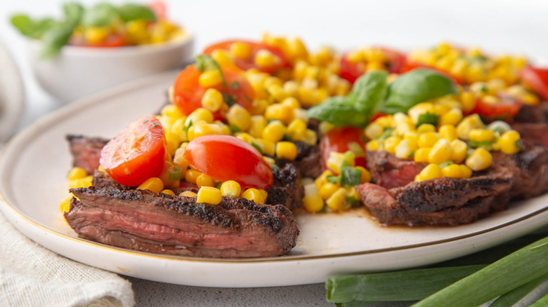 grilled skirt steak topped with tomato and corn salsa