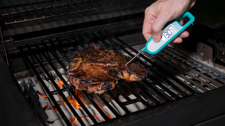 Meat thermometer testing grilled steak