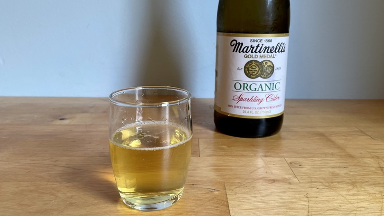 glass bottle of Martinelli's cider with glass cup