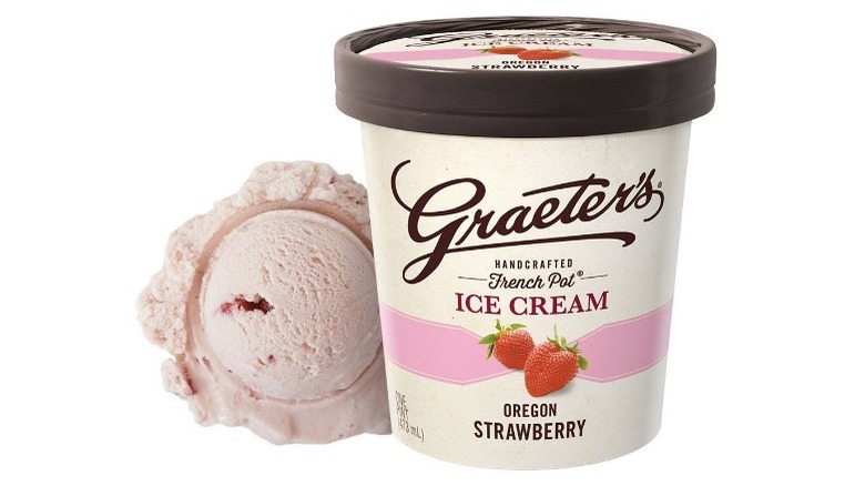 a pint of Graeter's Oregon strawberry ice cream next to a scoop of strawberry ice cream