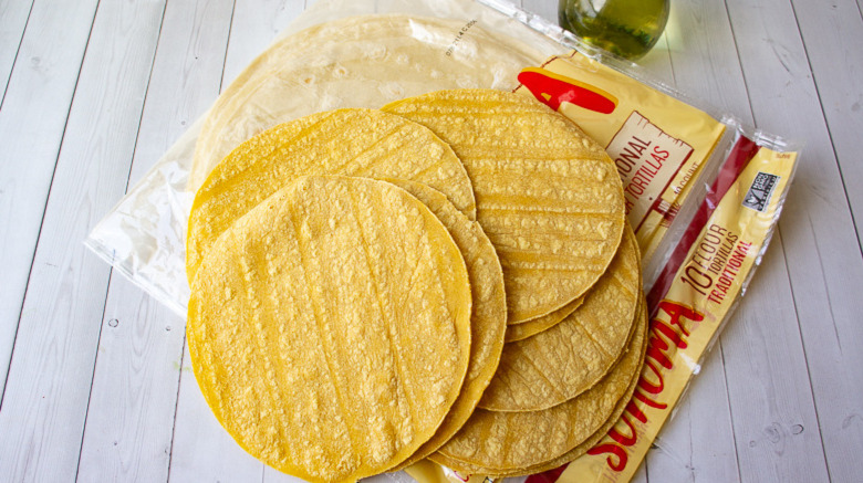 loose corn tortillas sitting on a package of flour tortillas 