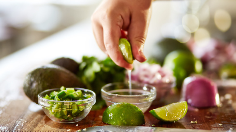 Person squeezing lime juice for guacamole