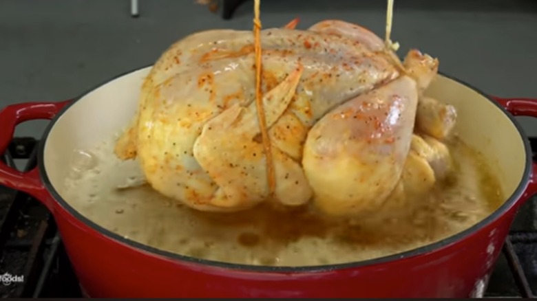 lowering chicken into butter to boil