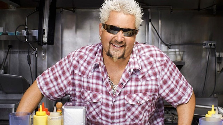 Guy Fieri in sunglasses on set in restaurant