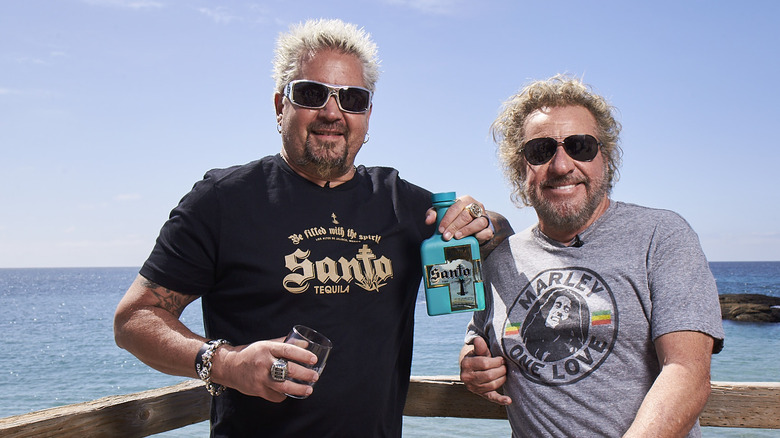 Sammy and Guy holding a bottle of Santo