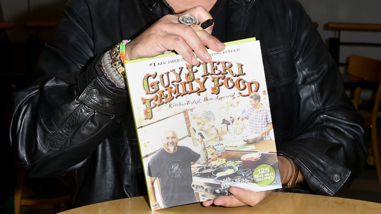 Fieri holds his book at signing