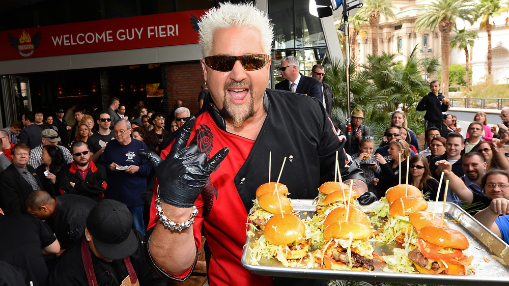 Guy Fieri posing and handing out burgers