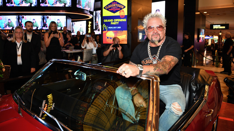 Guy Fieri sitting in a classic car