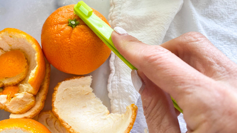 orange getting peeled on counter 