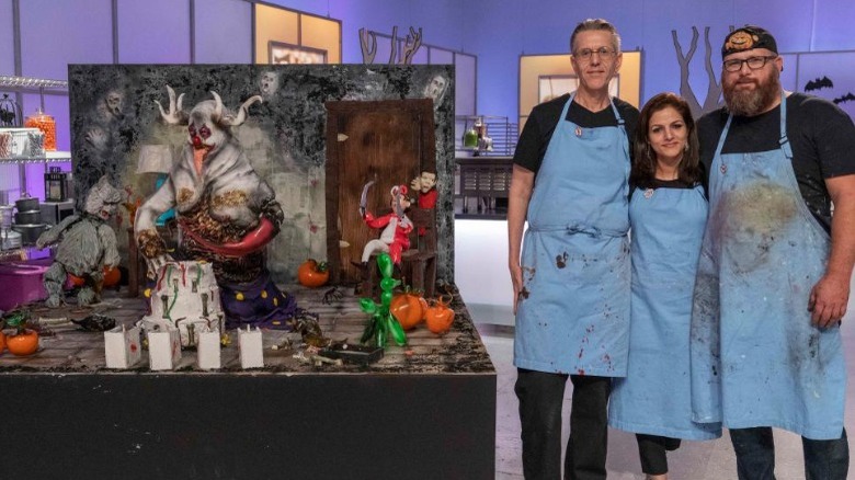 Halloween Wars contestants posing next to their dessert display