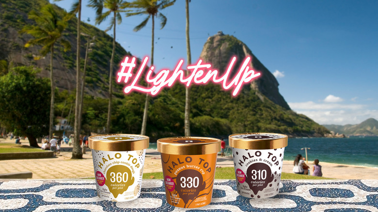 Three tubs of ice cream from Halo Top with a mountain and palm trees in background