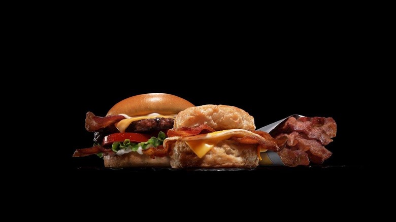 burger with candied bacon, biscuit with candied bacon, strips of candied bacon on black background