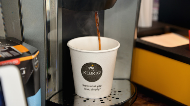 Keurig dispensing coffee into white cup with Keurig logo