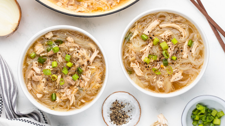 Two bowls of chicken noodle soup with green onions