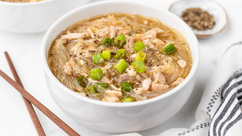 Bowl of chicken noodle soup with green onions