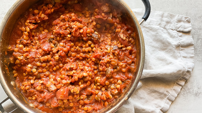 pot of lentil bolognese in skillet on kitchen towel