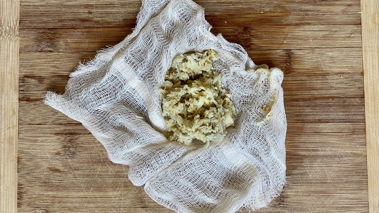 Miso Ginger Salad ginger squeezed in cheesecloth on cutting board