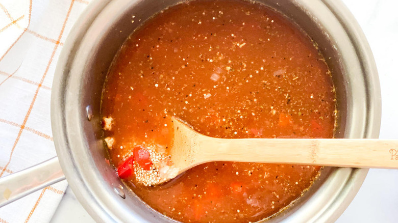 Quinoa cooking in broth in metal pot