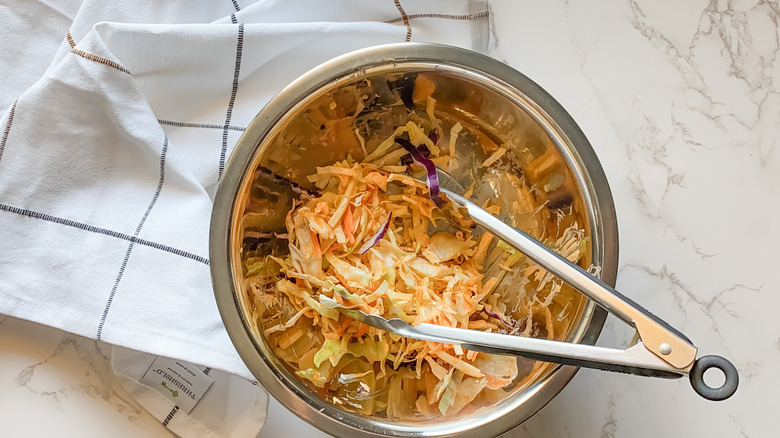 mixing cabbage for coleslaw