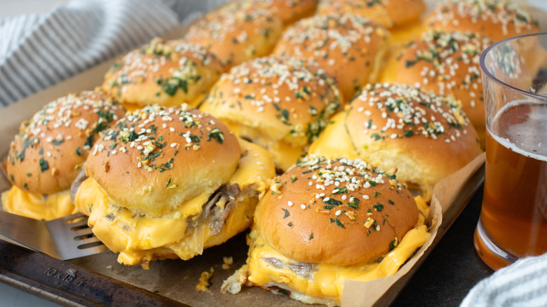 Sliders with cheese filling on paper-lined pan