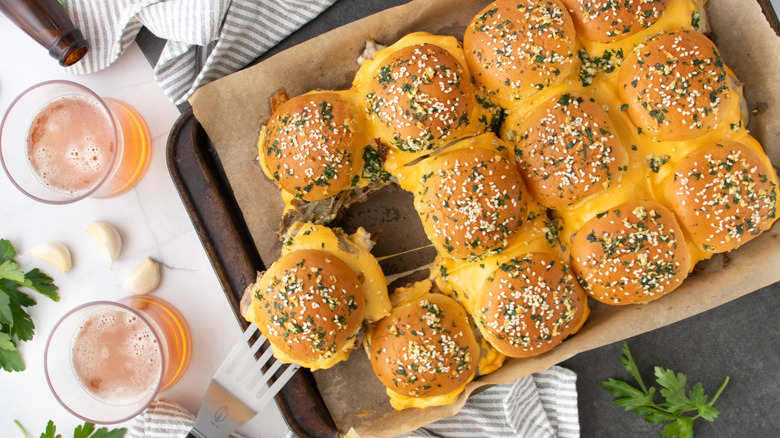 Sliders with cheese filling on paper-lined pan