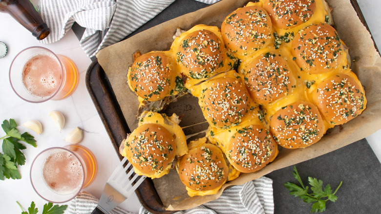 Sliders with cheese filling on paper-lined pan