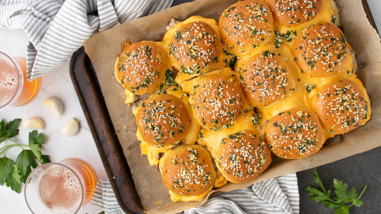 Sliders with cheese filling on paper-lined pan