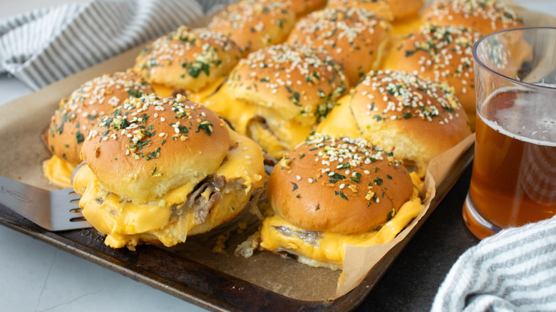 Sliders with cheese filling on paper-lined pan