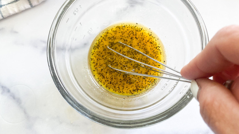 whisking salad dressing in bowl