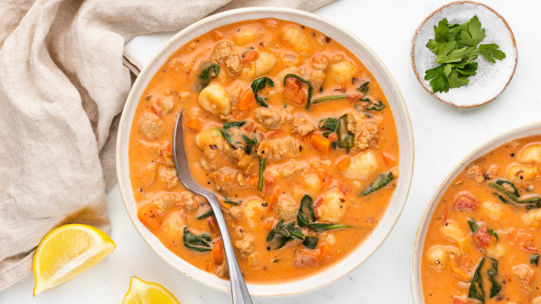 Bowl of creamy sausage gnocchi soup with spoon