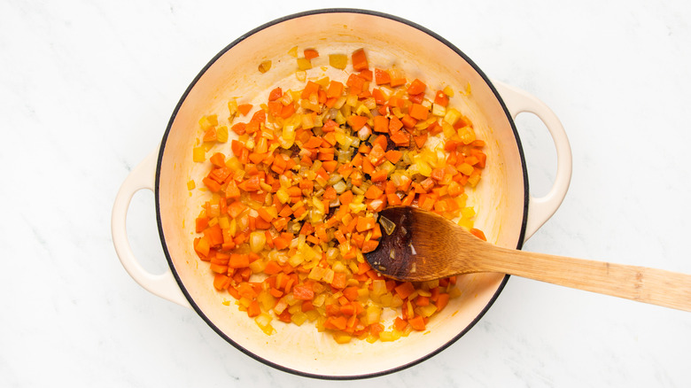 Onion, carrot, and garlic cooking in casserole pot