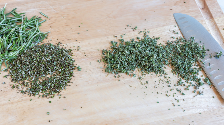 mincing fresh rosemary and thyme