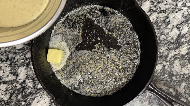 Butter and herbs in cast iron pan