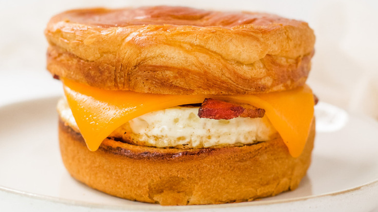 Croissant bun with egg, bacon, and cheese. 